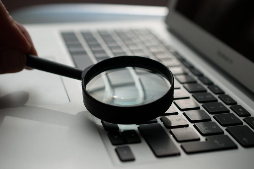 Quality and Governance - laptop and magnifying glass