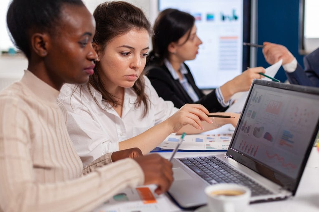 Cheerful african business lady typing on laptop